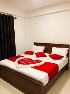 a bedroom with a large bed with red pillows at Little Heaven Villa in Ambawela