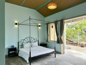 una camera da letto con un letto con baldacchino di metallo di Baya Beach Club 
