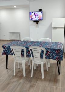 a dining room table with white chairs and a floral table cloth at Alvarez Apart in Ushuaia