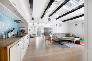 RødvigにあるLovely Bright Summer House Close To The Beachのソファとテーブルのあるキッチンとリビングルーム +30枚の写真