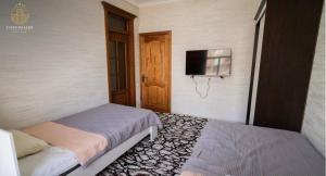 a bedroom with a bed and a tv on the wall at GREENChashmasor in Dushanbe