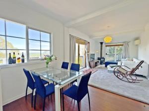 a living room with a glass table and blue chairs at La Cachette in Upwey 3BR Retreat with Mountain Views in Upwey +23 photos