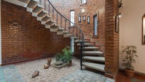 a brick wall with a spiral staircase in a house at Goshen in Bengaluru