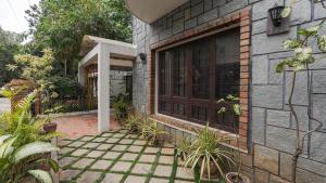 a brick house with a large window and plants at Goshen in Bengaluru