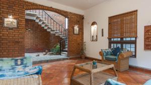 a living room with a brick wall at Goshen in Bengaluru +2 photos