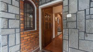 an entrance to a brick building with a wooden door at Goshen in Bengaluru