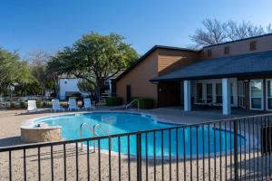 a swimming pool in front of a house at Landing Apartments - DeSoto in DeSoto