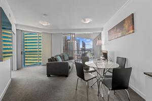a living room with a table and chairs and a couch at Evolve Apartments Brisbane in Brisbane