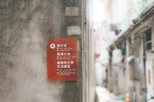 un cartel rojo en el costado de un edificio en 稻禾棧, en Longtan