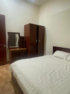 une chambre avec un lit, une commode et un miroir dans l'établissement Bungalow Tina, à Duong Dong