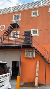 an orange building with a staircase on the side of it at Furnished apartment 10 minutes from the consulate in Manuel F. Martínez