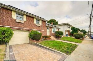 una casa in mattoni con vialetto e garage di Belmont Lux Escape a Elmont