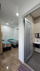 a room with two beds and a door to a bathroom at D'Villa Roomstay in Tangkak