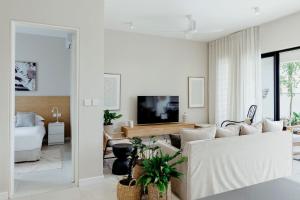 Una sala de estar con un sofá y un televisor. en Luxury Golf Villa at Azuri - with beach access, en Roches Noires