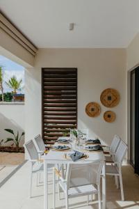 Un comedor blanco con una mesa y sillas blancas. en Luxury Golf Villa at Azuri - with beach access, en Roches Noires