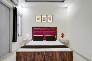 a bedroom with a large bed with a wooden headboard at Hotel O Meerut Central College Formerly Saffron in Meerut +21 photos