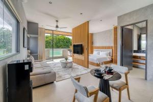 a bedroom with a bed and a living room with a table at Elourea 1BR Apt Rooftop Jacuzzi In Uluwatu in Uluwatu