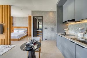 a kitchen and living room with a bed in a room at Elourea 1BR Apt Rooftop Jacuzzi In Uluwatu in Uluwatu