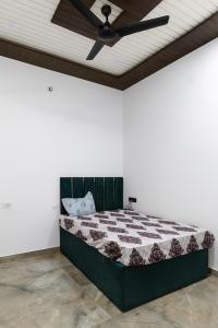 a bedroom with a bed with a ceiling fan at Bhoomi Home Stay in Mathura +10 photos