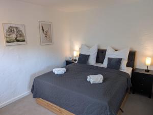 a bedroom with a large bed with two towels on it at Torfzeit in Worpswede