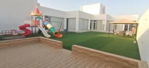 une cour arrière avec une aire de jeux. dans l'établissement شاليه السكون, à Ras al Hadd