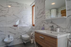 a white bathroom with a sink and a toilet at Weiss Sport & Relax Apartment - Happy Rentals in Rečica ob Savinji