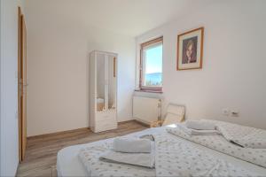 a white bedroom with a bed and a window at Weiss Sport & Relax Apartment - Happy Rentals in Rečica ob Savinji