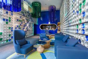 a room with blue chairs and a wall of vases at Room Mate Oscar in Madrid