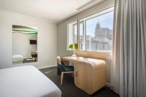 a bedroom with a desk and a bed and a window at Room Mate Oscar, Madrid in Madrid
