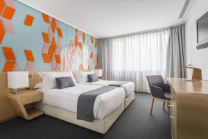 a hotel room with two beds and a desk at Room Mate Oscar, Madrid in Madrid
