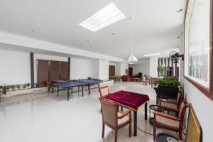 Una sala de estar con mesas y sillas en una habitación. en GreenTree Inn Express Suzhou Luzhi Ancient Town Scenic Area Xiaoshi Road, en Suzhou