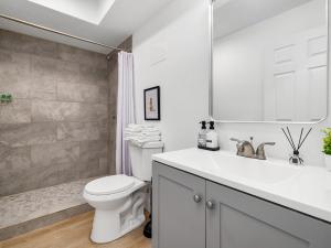 a white bathroom with a toilet and a sink at Casitas en Pueblo - Central Lofts in Pueblo