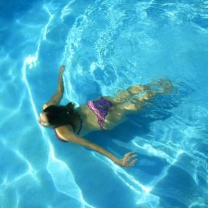 a woman is floating in a pool of water at Hotel Sport in Bełchatów