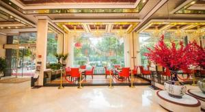 a lobby with red chairs and a large window at Milu Hotel in Guangzhou