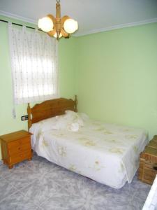 um quarto com uma cama e um lustre em Casa Rural El Carrascal em Valdefuentes de Sangusín