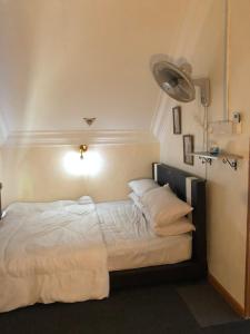a bed with white sheets and pillows in a room at Abe.Cottage 3 in Kampong Chawat +5 photos