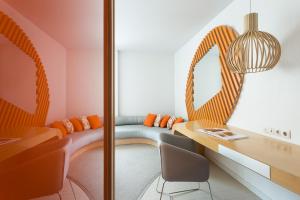 a room with a bench and a table and chairs at Room Mate Oscar, Madrid in Madrid