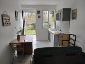 a kitchen with a table and a counter top at Le moulin aux lunettes in Sablonnières