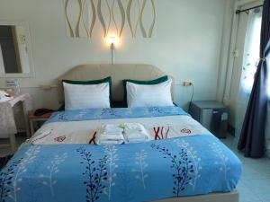 a bedroom with a bed with two towels on it at Happy Home Guest House in Ban Phe