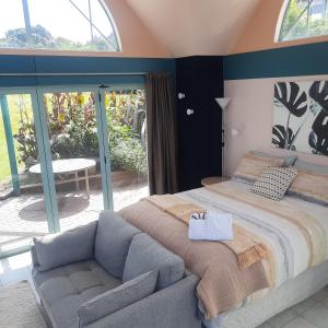 a bedroom with a large bed and a couch at The Quarters Ocean-View Chalet in Gisborne