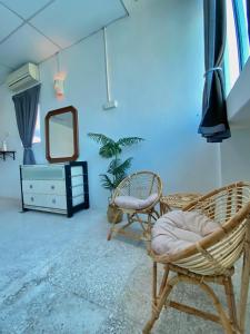 a room with two chairs and a mirror and a dresser at Sembilan Inn by Soft Loft in George Town