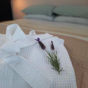 a white napkin with a flower on a bed at The Quarters Ocean-View Chalet in Gisborne +7 photos