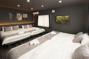 a bedroom with two beds with towels on them at Central Stay Sapporo 札幌中心部 最大24名 キッズルーム in Sapporo