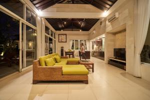 a living room with a yellow couch and a table at 3Bedroom Umasari Villa in Keramas +43 photos