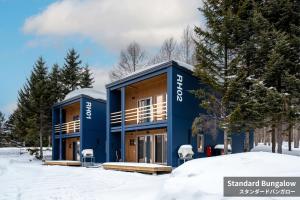 a blue building in the snow with trees at Rusutsu Hills CENTRO in Rusutsu