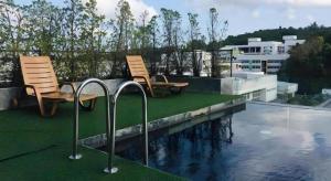 two chairs sitting next to a swimming pool at Neca Reiche in Hat Yai