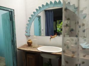 un bagno con lavandino e specchio di Hanuman Heights a Unawatuna Altre 3 foto