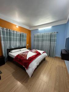 a bedroom with a large bed and a television at HotelSonamTawang in Tawang