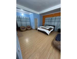 a bedroom with a bed and a wooden floor at HotelSonamTawang in Tawang +1 photo