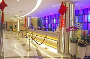 a lobby with a staircase and flowers in a building at Golden Central Hotel Shenzhen in Shenzhen